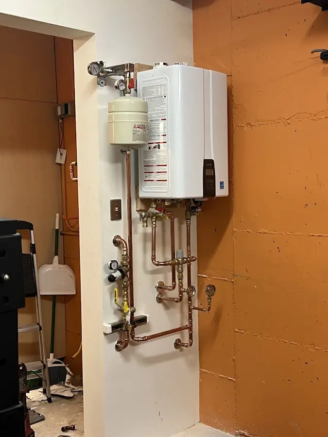 Plumbing technician inspecting water heater connections in South Whittier